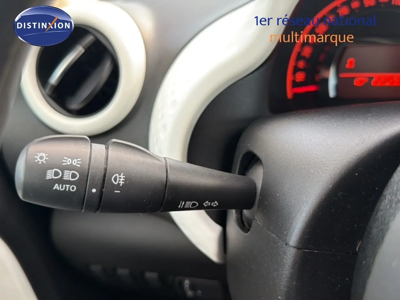 Gros plan sur la manette de commande des phares et clignotants dans l'habitacle d'une Renault Twingo gris acier.