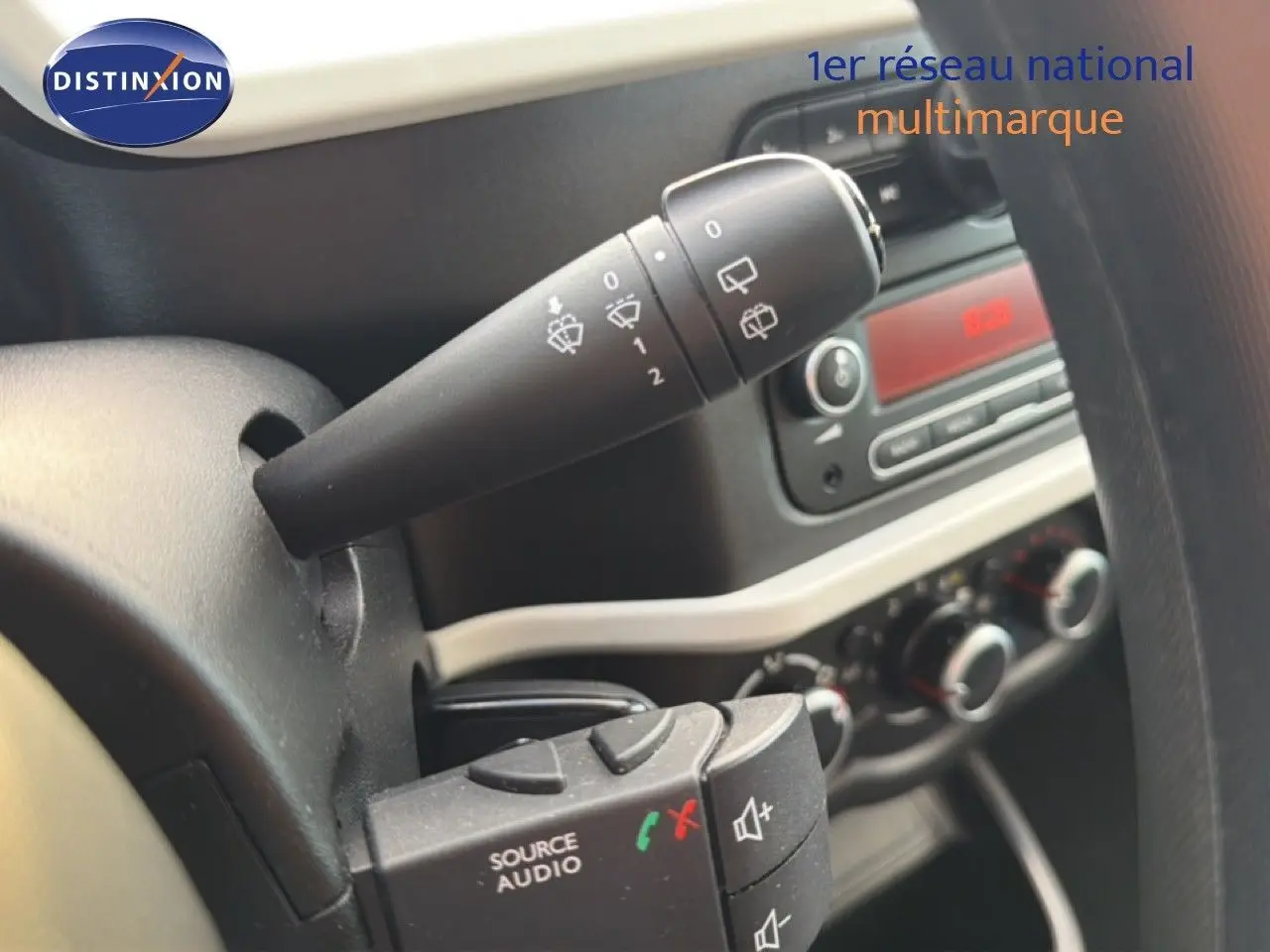 Gros plan sur les commandes au volant et la manette d’essuie-glace du tableau de bord d’une Renault Twingo gris acier.