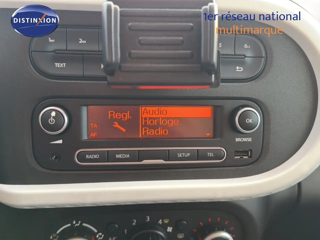 Gros plan sur la console centrale de la Renault Twingo gris acier 2021, affichant l’écran radio et les commandes audio.