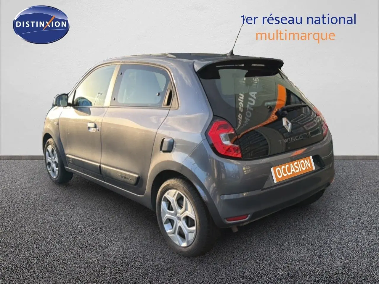 Vue 3/4 arrière droite d'une Renault Twingo gris acier 2021, compacte avec feux LED et cinq portes visibles.