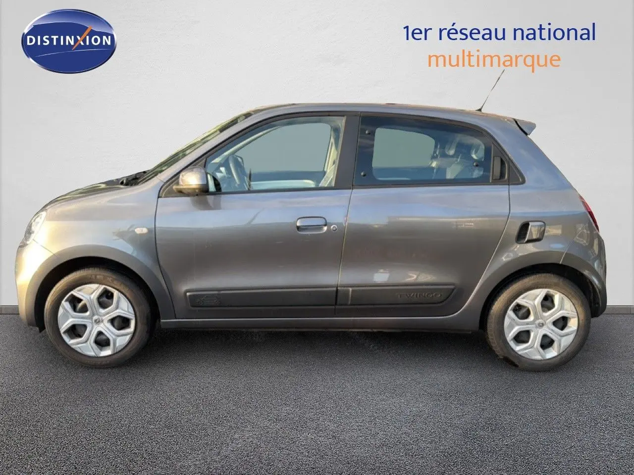 Vue de profil côté gauche d'une Renault Twingo 1.0 SCE 65 Zen gris acier à 5 portes, avec jantes distinctives et finition tissu.