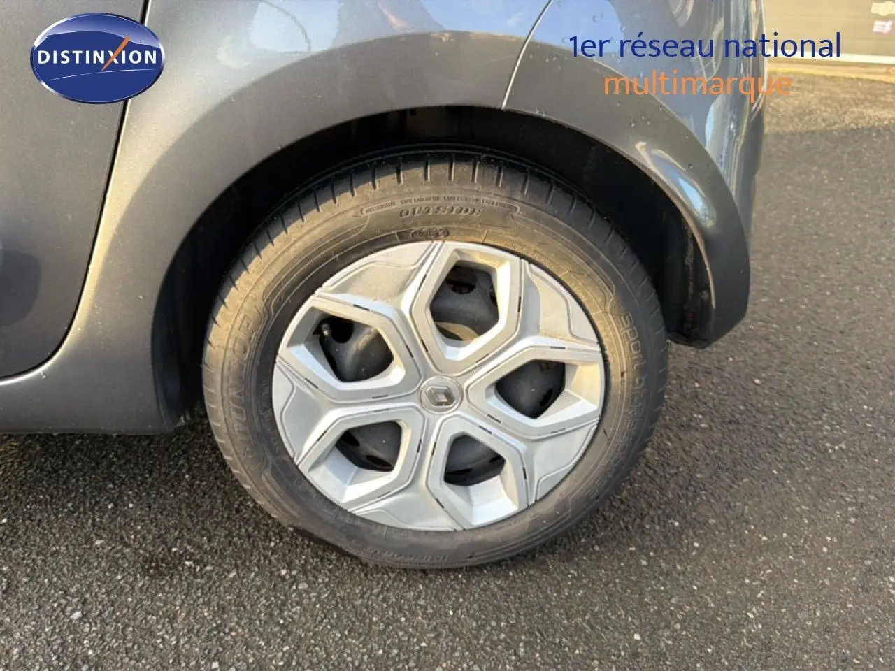 Gros plan sur la roue arrière droite d'une Renault Twingo gris acier, mettant en valeur la jante au design moderne.