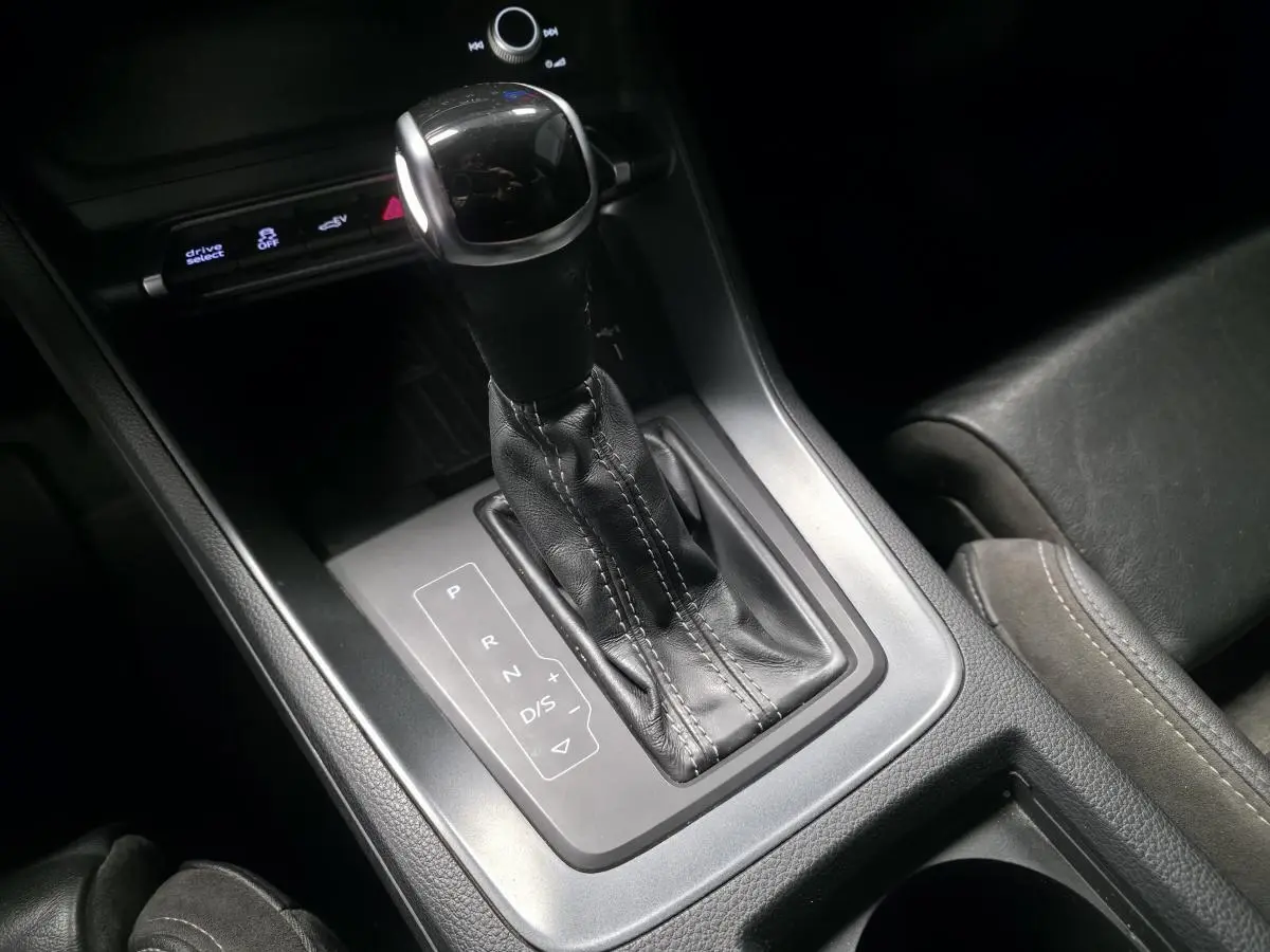 Gros plan sur le levier de vitesse automatique noir et argenté de l'Audi Q3 S Line 2021, intérieur cuir noir.