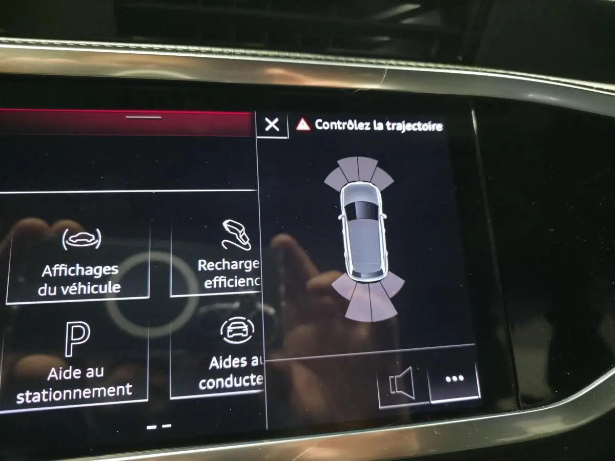 Affichage intérieur de l'Audi Q3 hybride rechargeable montrant l'aide au stationnement et le contrôle de trajectoire.