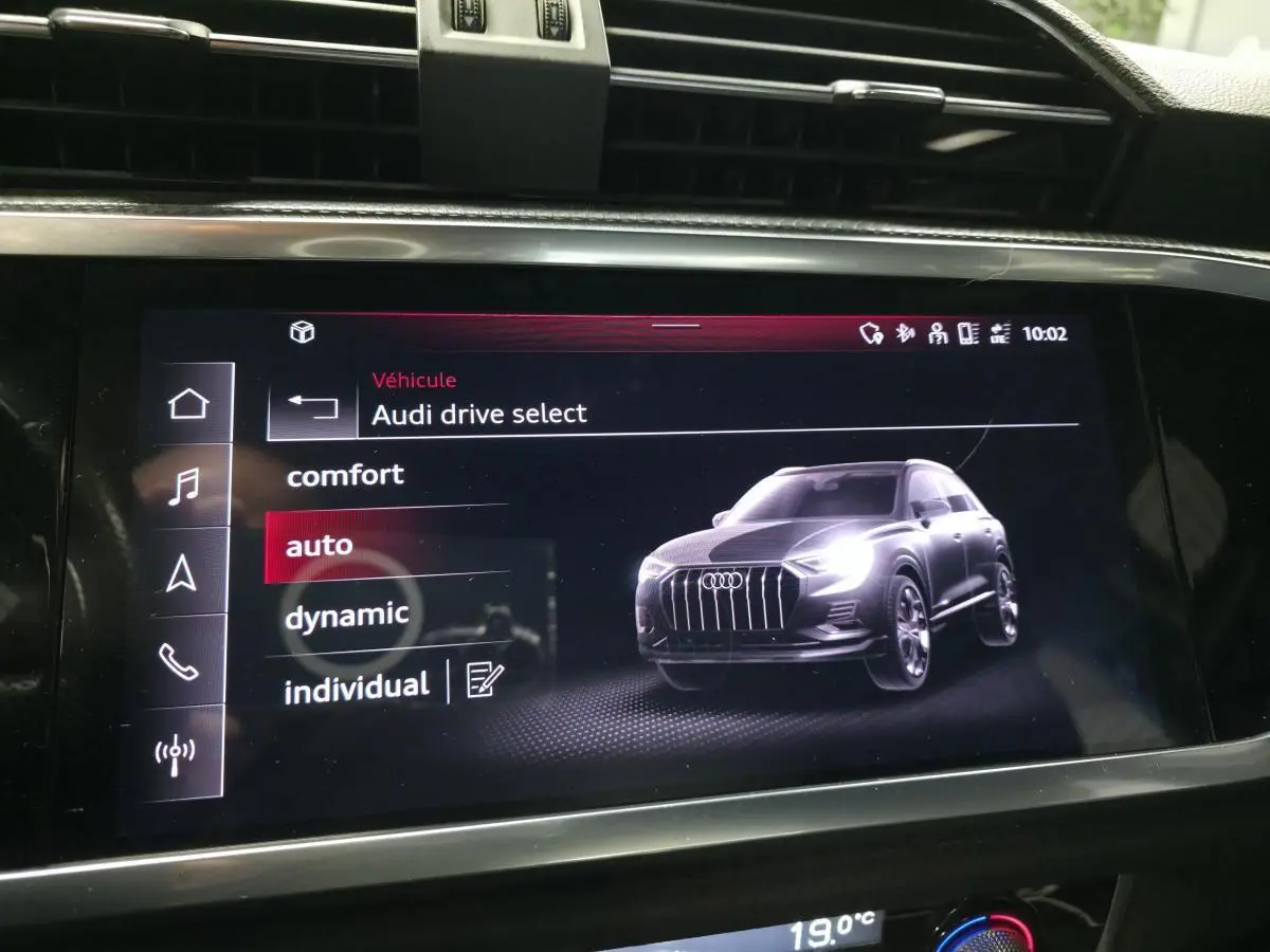 Écran tactile intérieur affichant le menu Audi Drive Select avec une image 3D grise du SUV Audi Q3 en vue avant 3/4.