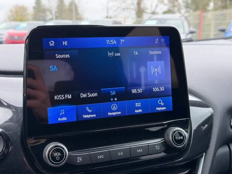 Écran tactile central du Ford Puma 2024 affichant la radio DAB, avec commandes audio et navigation visibles.