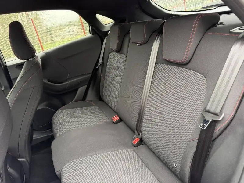 Vue intérieure côté droit des sièges arrière gris foncé avec surpiqûres rouges du Ford Puma 2024.