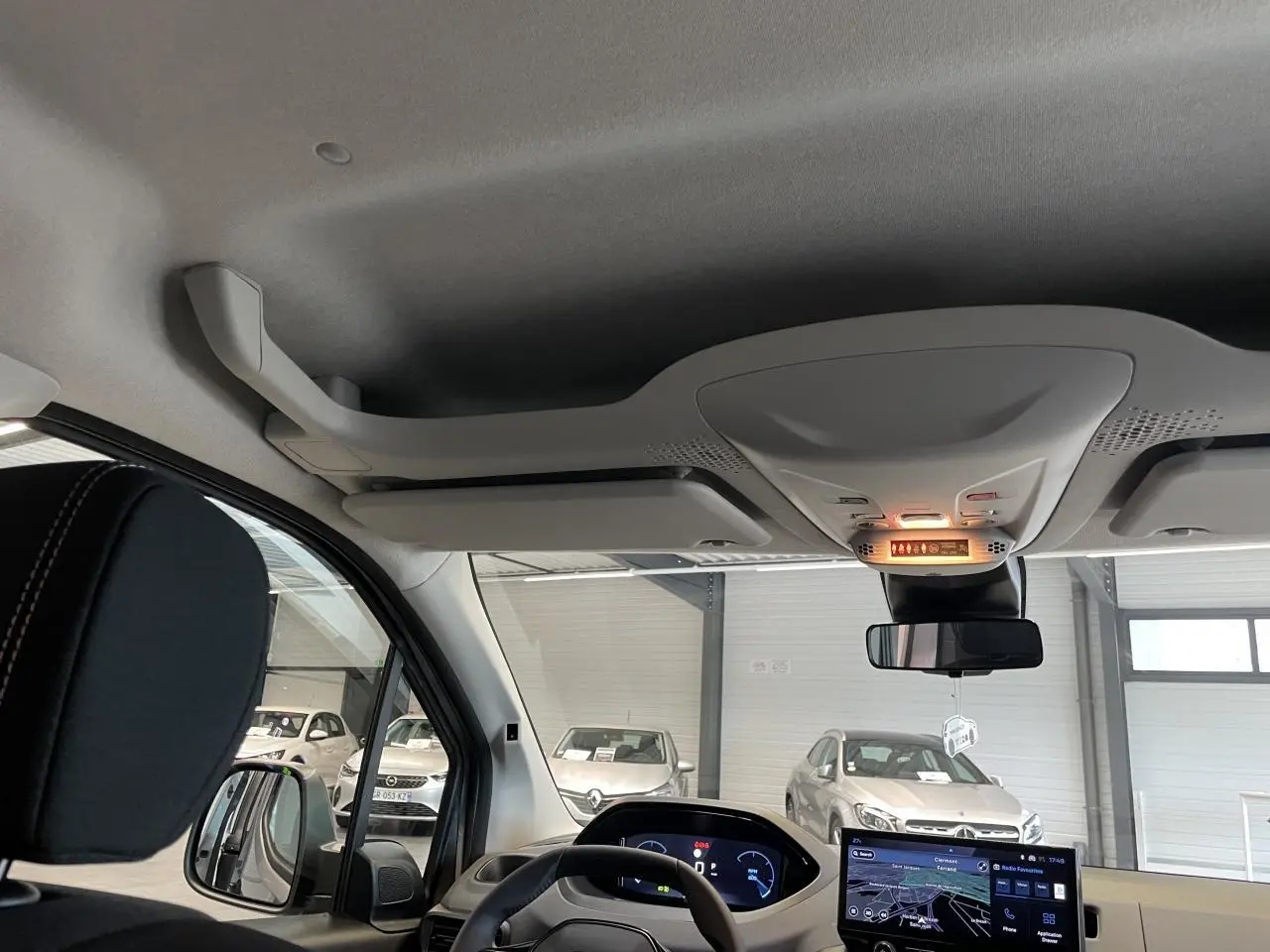 Vue intérieure avant du Peugeot Rifter gris Artense, montrant le volant cuir multifonction et l'écran tactile central allumé.