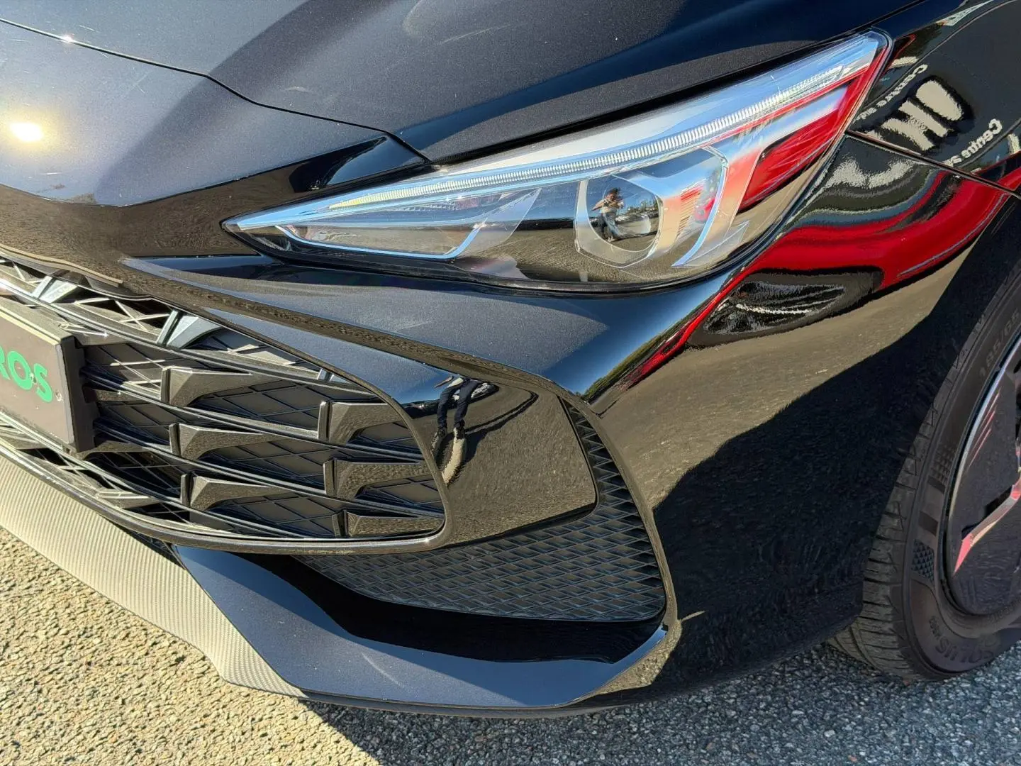 Gros plan sur l'avant droit du MG3 1.5 Hybrid+ 2024 en Pebble Black métallisé, mettant en valeur le phare et la calandre.