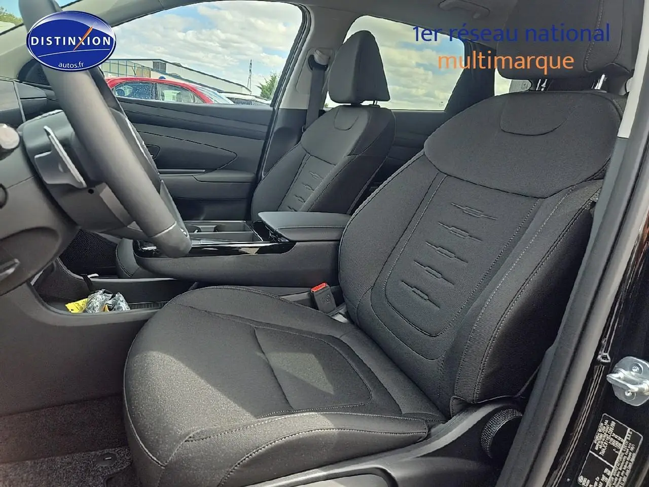 Intérieur du Hyundai Tucson 2025 noir abysse, vue côté gauche sur les sièges avant en tissu noir et console centrale.
