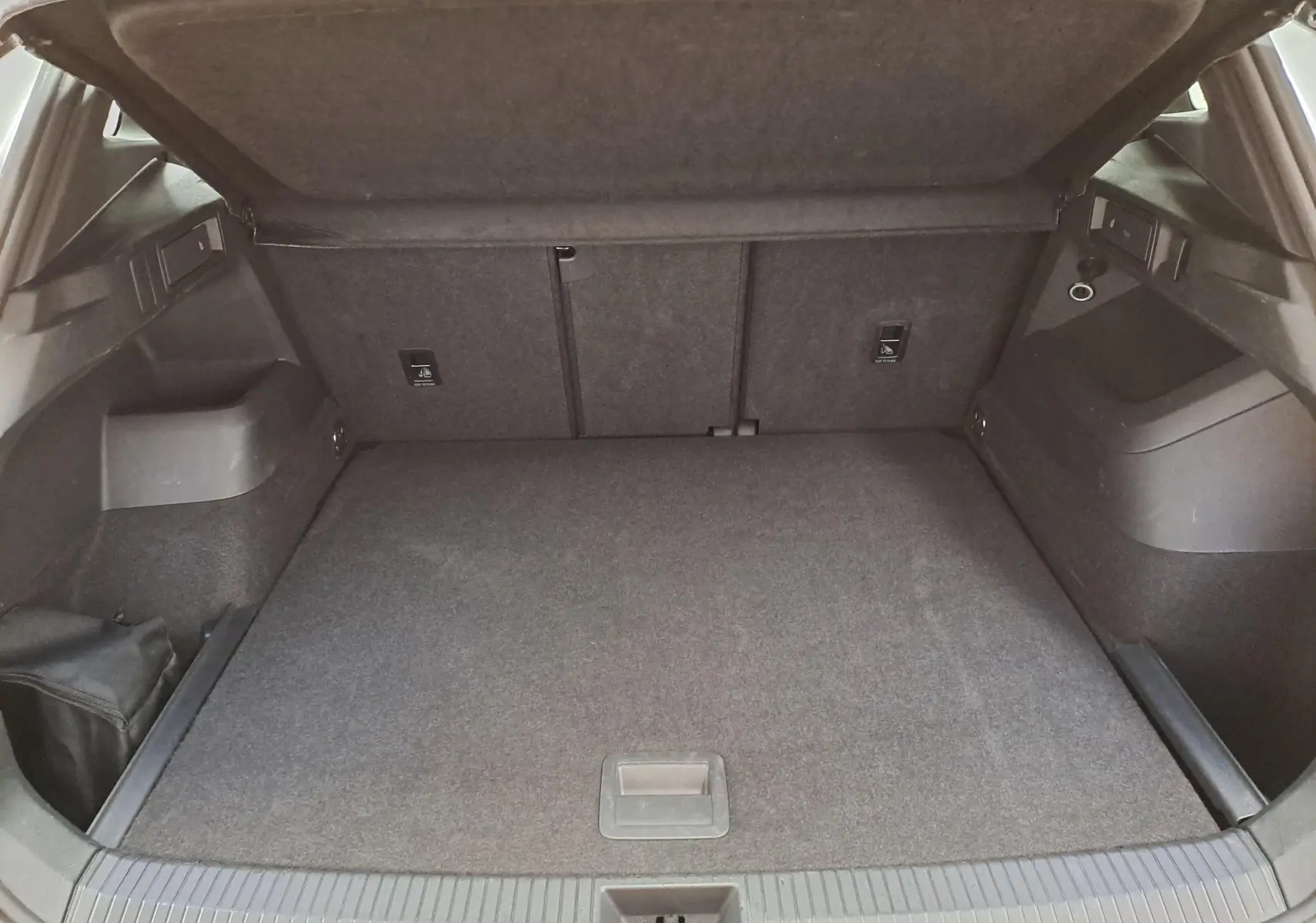 Coffre ouvert en vue arrière du Volkswagen Tiguan 1.5 eTSI blanc, montrant un espace de chargement propre et spacieux.