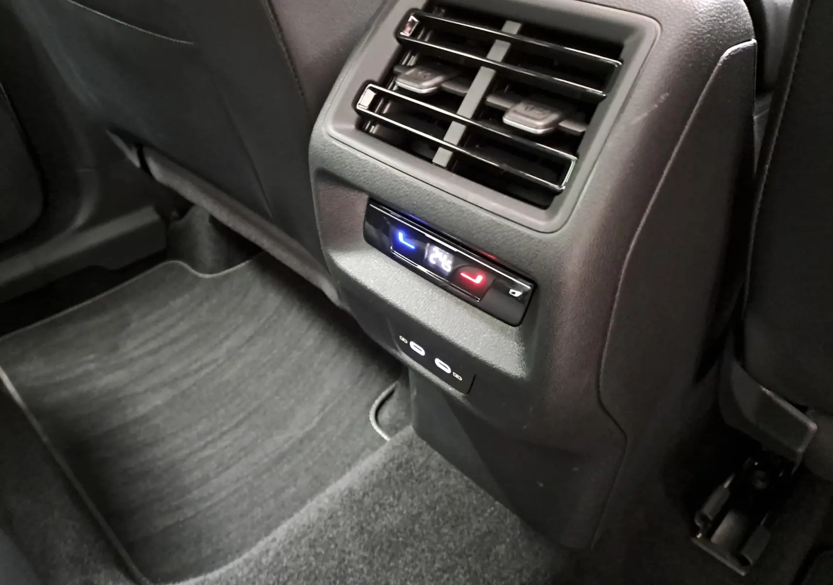 Détail de la console arrière avec aérateurs et commandes de climatisation dans un Volkswagen Tiguan blanc pur 2025.