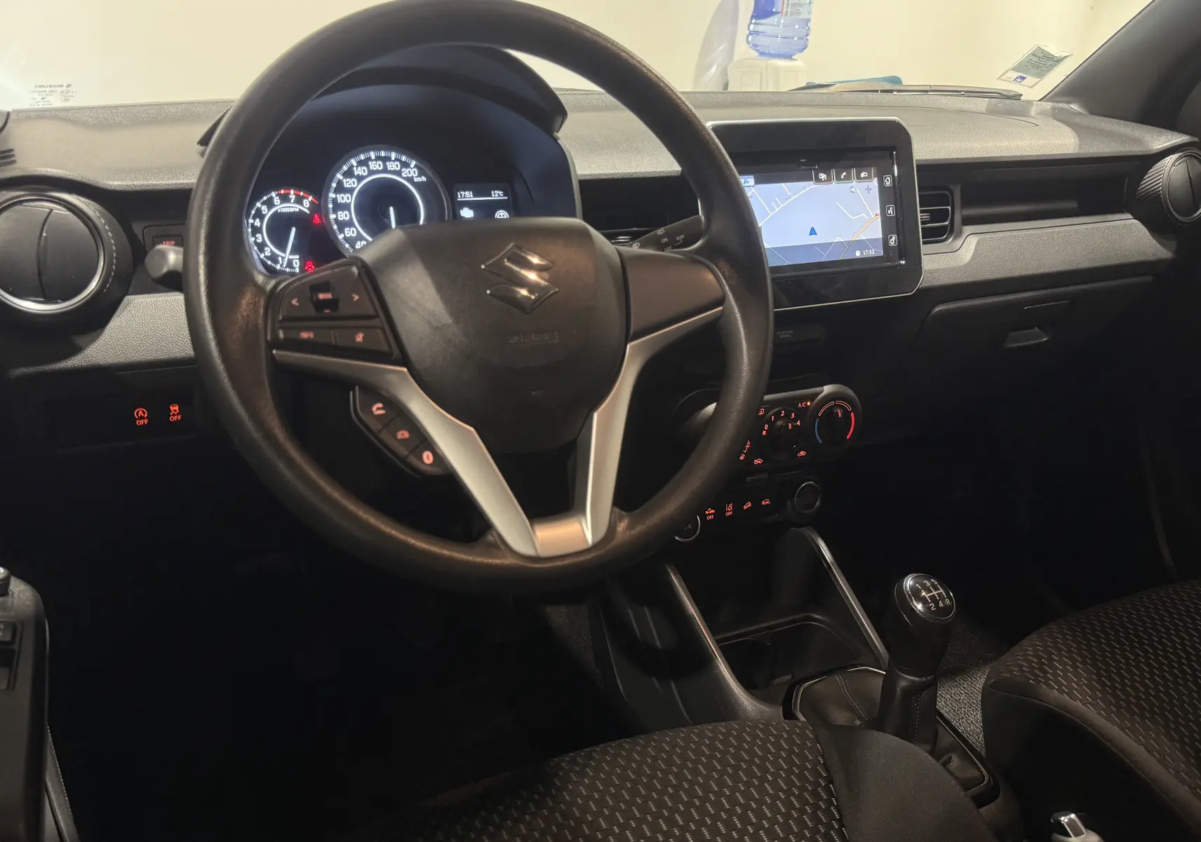 Vue intérieure centrée sur le volant et la console centrale d'une Suzuki Ignis 2022, avec boîte manuelle et écran tactile.
