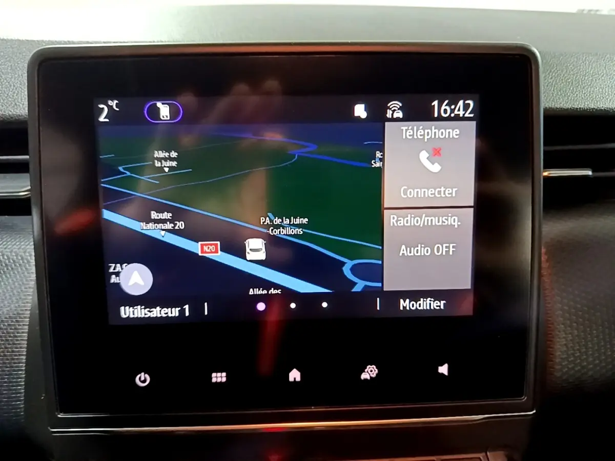 Écran tactile central du tableau de bord de la Renault Clio Business bleu, affichant la navigation et options téléphone.