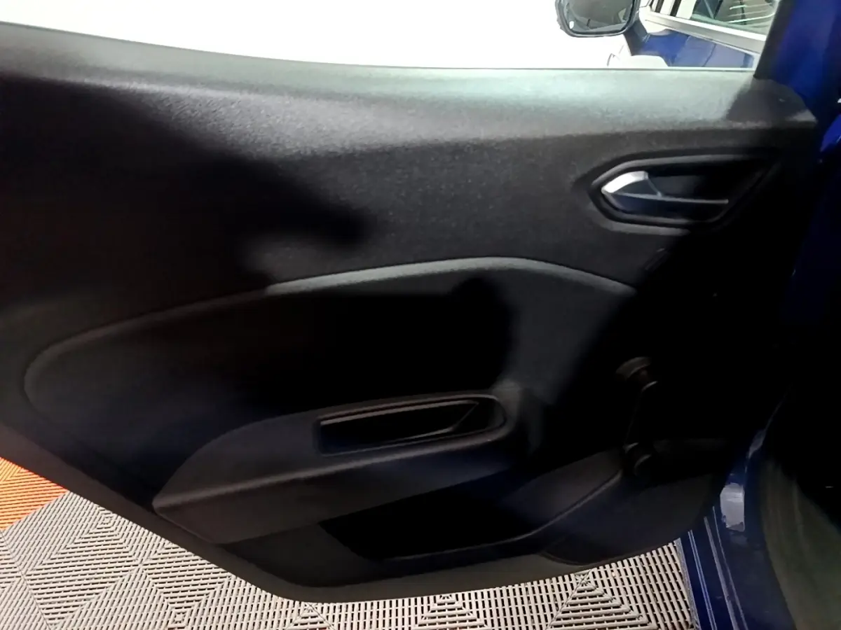 Vue intérieure de la porte arrière droite d'une Renault Clio Business bleu 2022, avec poignée et panneau noir.