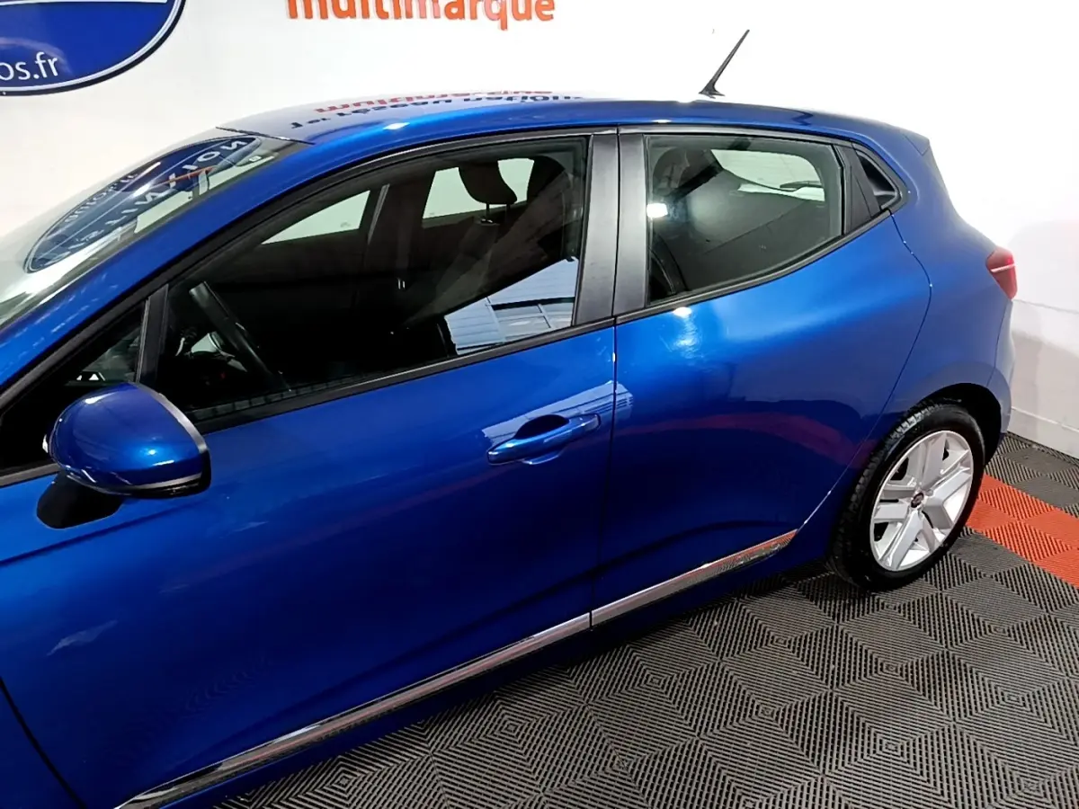 Vue latérale côté gauche d'une Renault Clio Business bleu métallisé, mettant en valeur la ligne fluide et les jantes alliage.