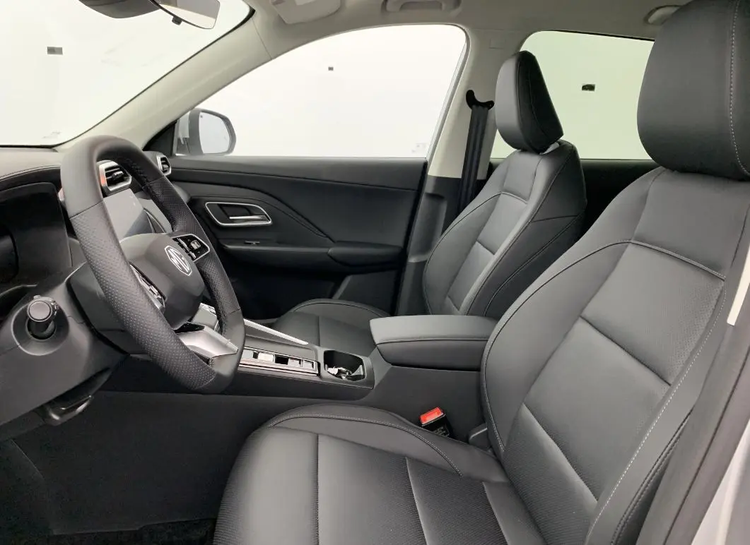 Vue intérieure côté conducteur du MG ZS 1.5 L HYBRID+ 197 CH Luxury 2026, sièges en cuir noir et tableau de bord moderne.