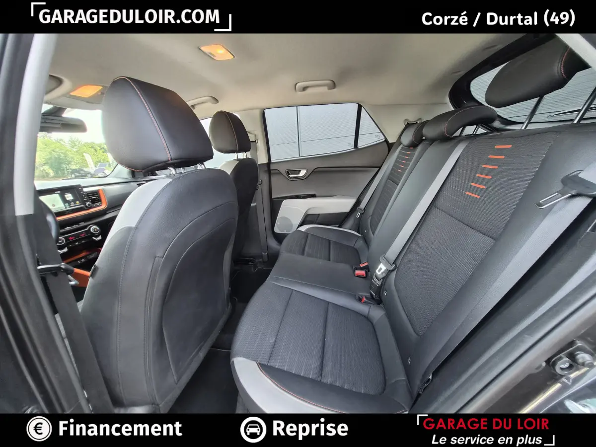 Vue intérieure côté droit montrant la banquette arrière noire avec surpiqûres orange du Kia Stonic 2019.