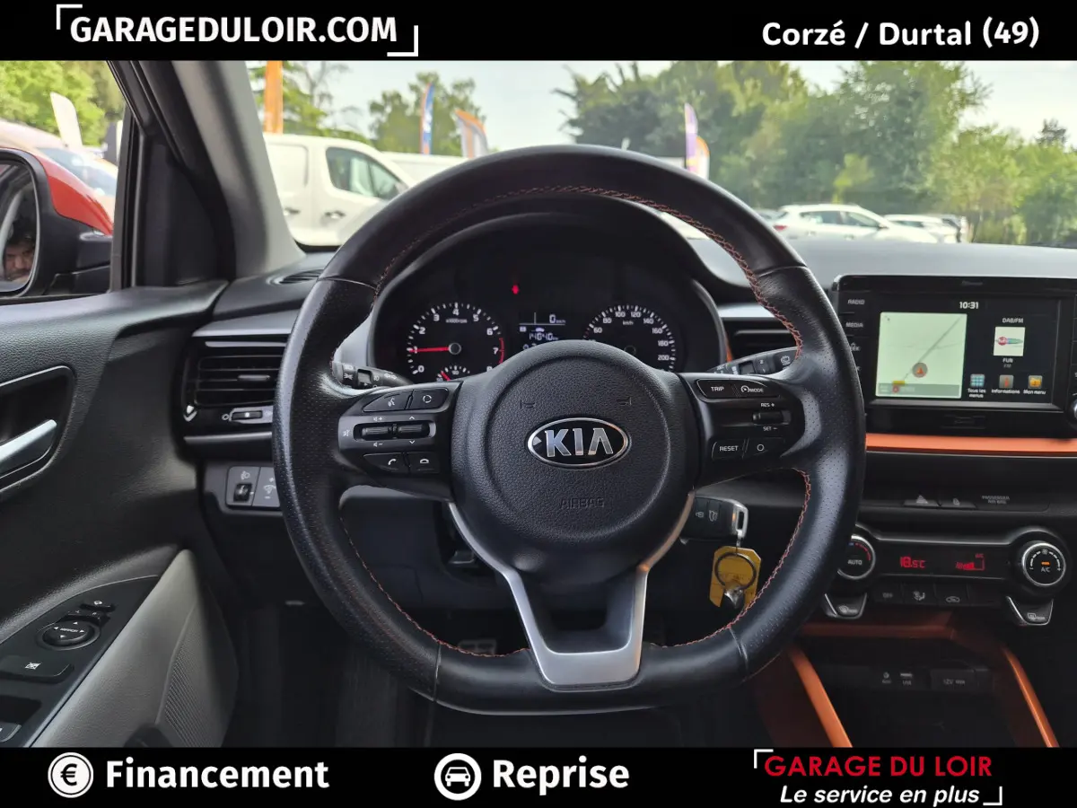 Vue intérieure centrée sur le volant cuir noir avec surpiqûres orange du Kia Stonic 2019, tableau de bord et écran tactile visibles.