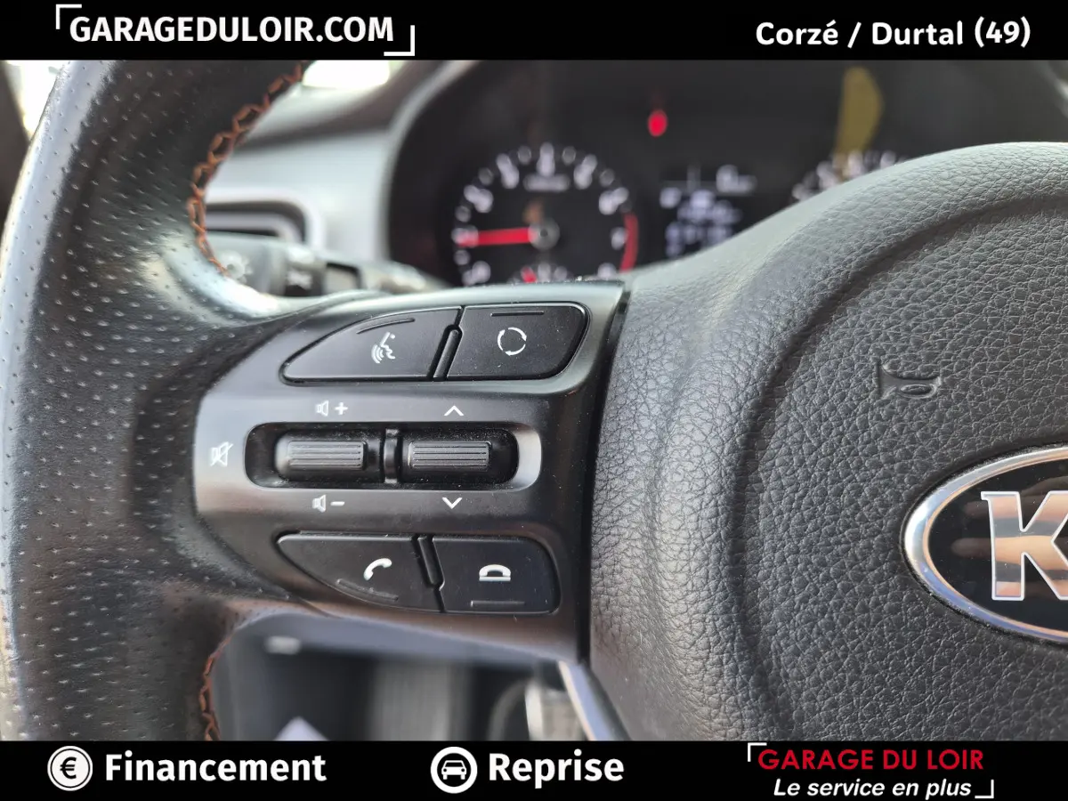 Gros plan sur les commandes du volant en cuir noir perforé d’un KIA STONIC 1.0 T-GDi 2019, côté gauche.