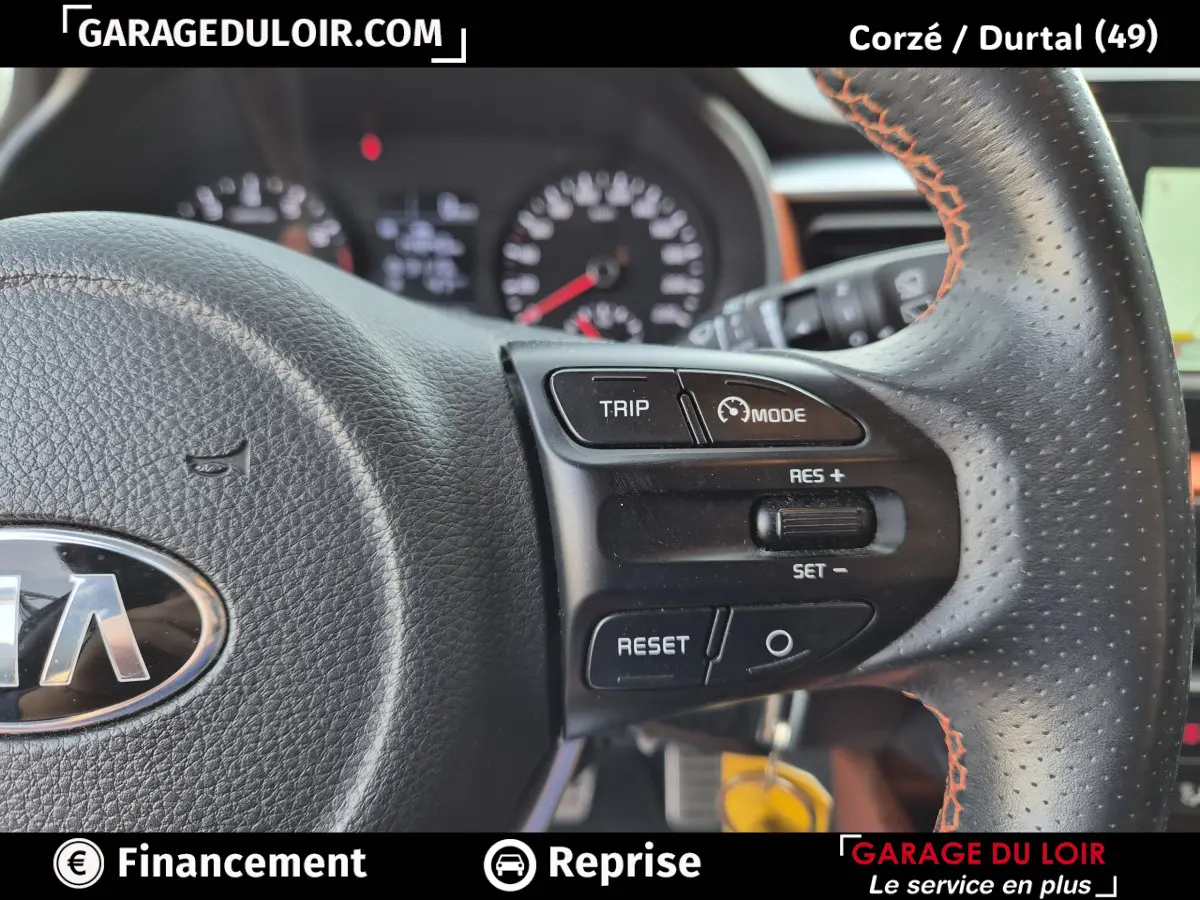 Gros plan sur le volant cuir noir avec surpiqûres orange du Kia Stonic 2019, montrant les commandes de régulateur de vitesse.