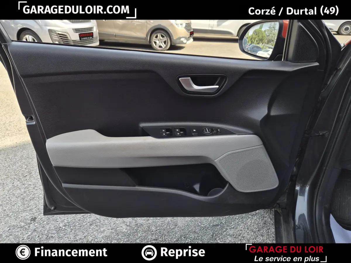 Vue intérieure côté gauche de la porte avant d'une KIA STONIC 2019 avec garniture noire et beige et commandes électriques.