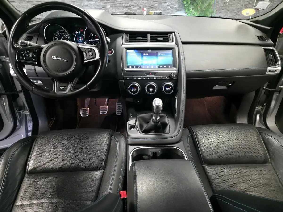 Vue intérieure frontale du tableau de bord noir et volant cuir multifonction de la Jaguar E-PACE D150 AWD 2019.