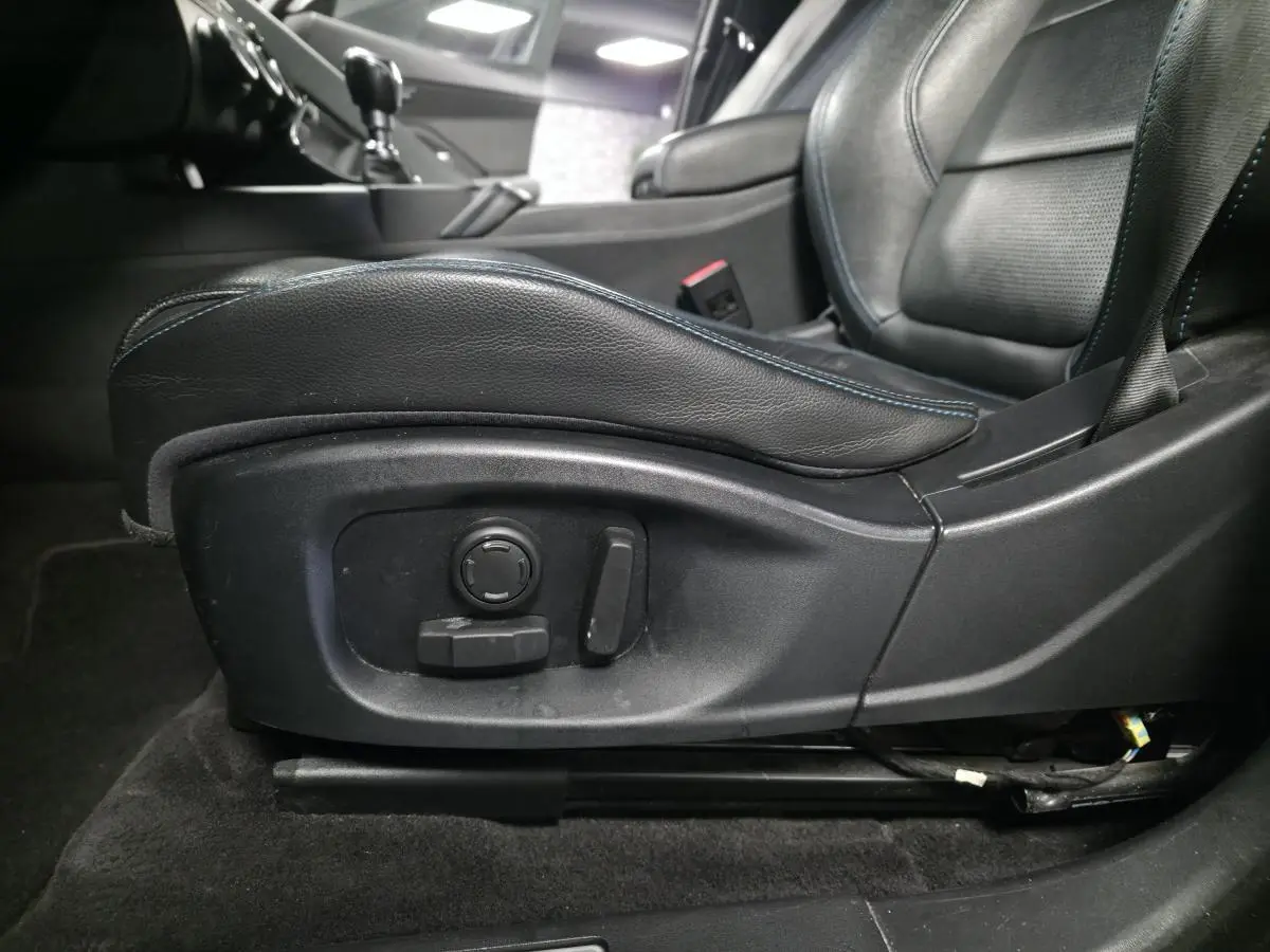 Gros plan sur le siège avant conducteur en cuir noir avec réglages électriques, intérieur du Jaguar E-PACE D150 gris 2019.