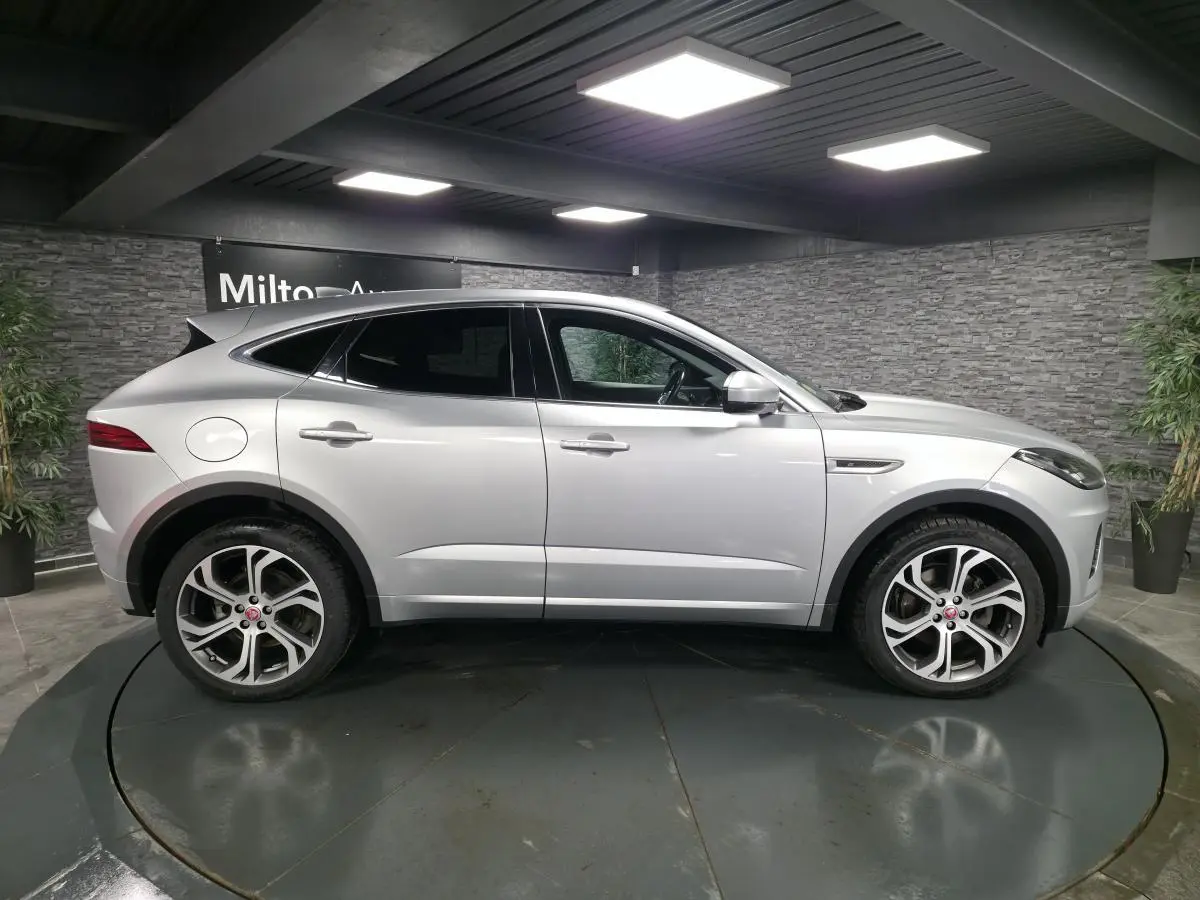 Jaguar E-PACE gris vue de profil côté gauche, avec jantes 20 pouces et vitrage arrière fumé.