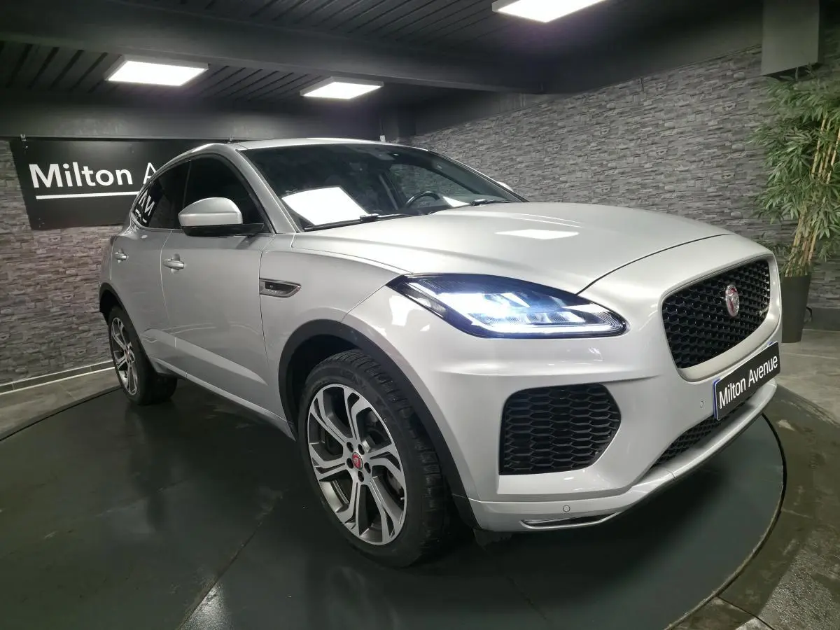 Jaguar E-PACE gris vue 3/4 avant droit avec phares LED allumés et jantes 20 pouces style 6014.