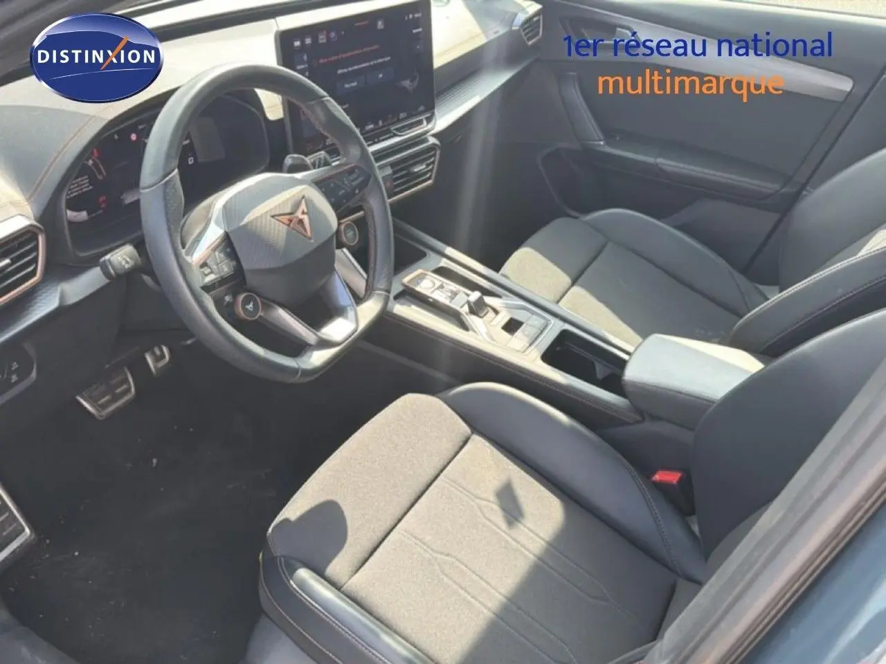 Vue intérieure côté conducteur du CUPRA Formentor gris magnétique, mettant en valeur le volant multifonction et la console centrale moderne.