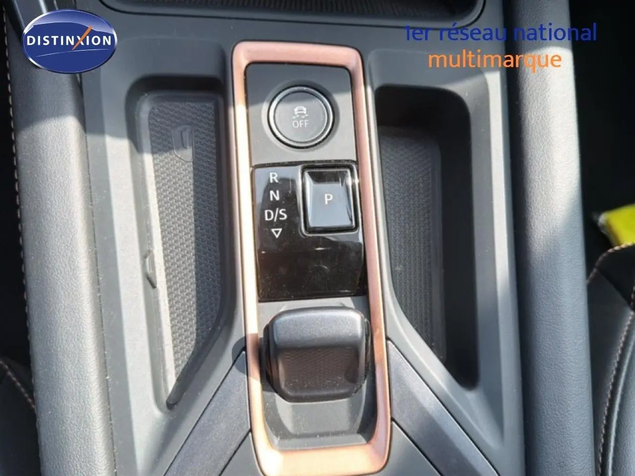 Vue rapprochée de la console centrale avec sélecteur de boîte auto et bouton de contrôle, intérieur gris et noir.