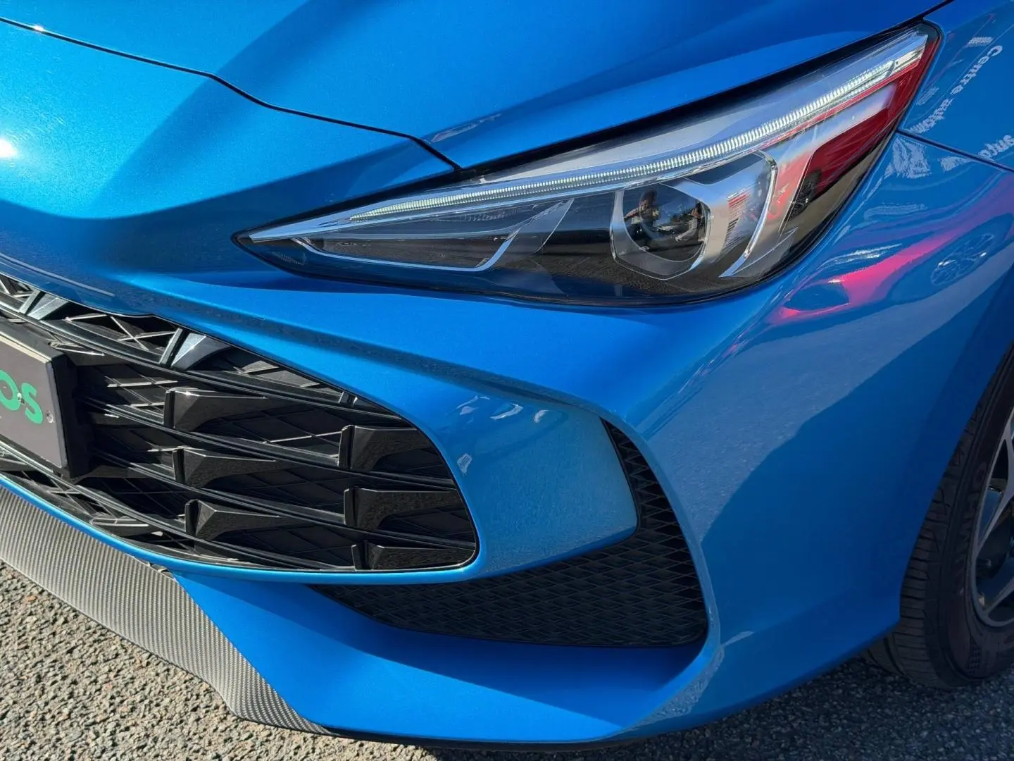 Gros plan sur l'avant droit bleu Como métallisé du MG3 1.5 Hybrid+ 195ch avec optique et calandre distinctifs.