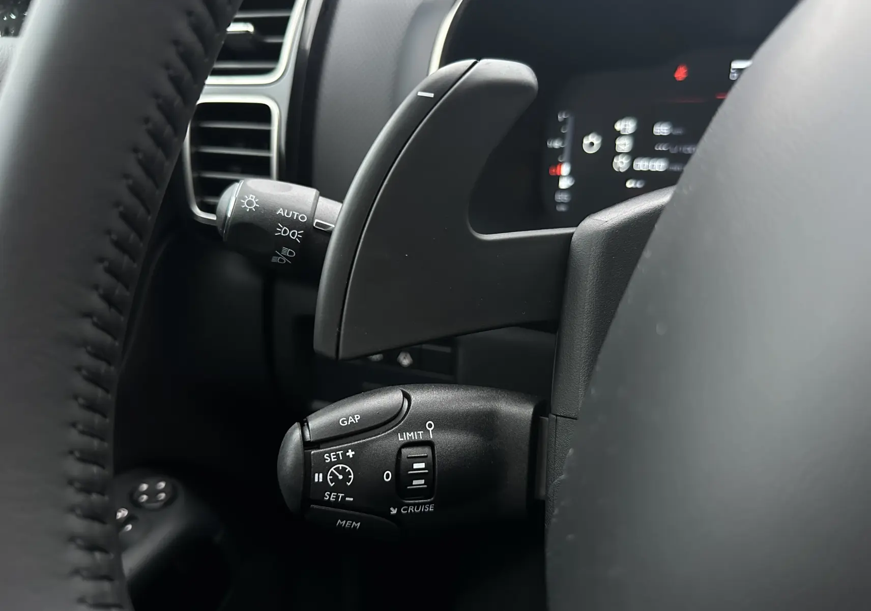 Gros plan sur la commande de régulateur de vitesse au volant d'une Citroën C5 Aircross 2025, intérieur noir.