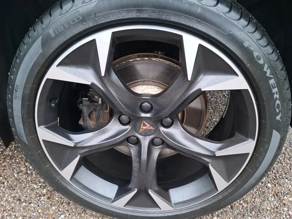 Gros plan sur la jante noire et argentée avec logo CUPRA au centre, montée sur pneu Pirelli Powergy.