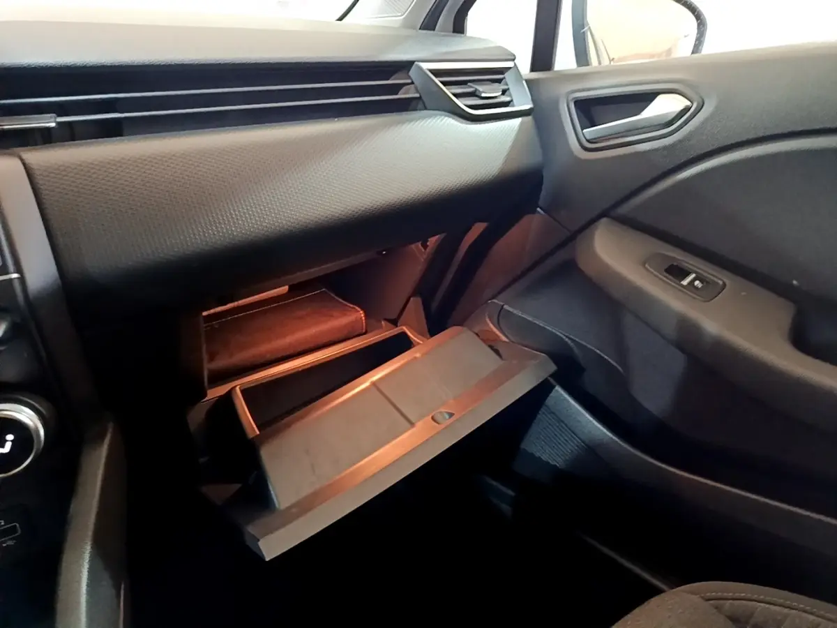 Vue intérieure côté passager de la Renault Clio Business TCe 100 2020, boîte manuelle, avec boîte à gants ouverte et tableau de bord noir.