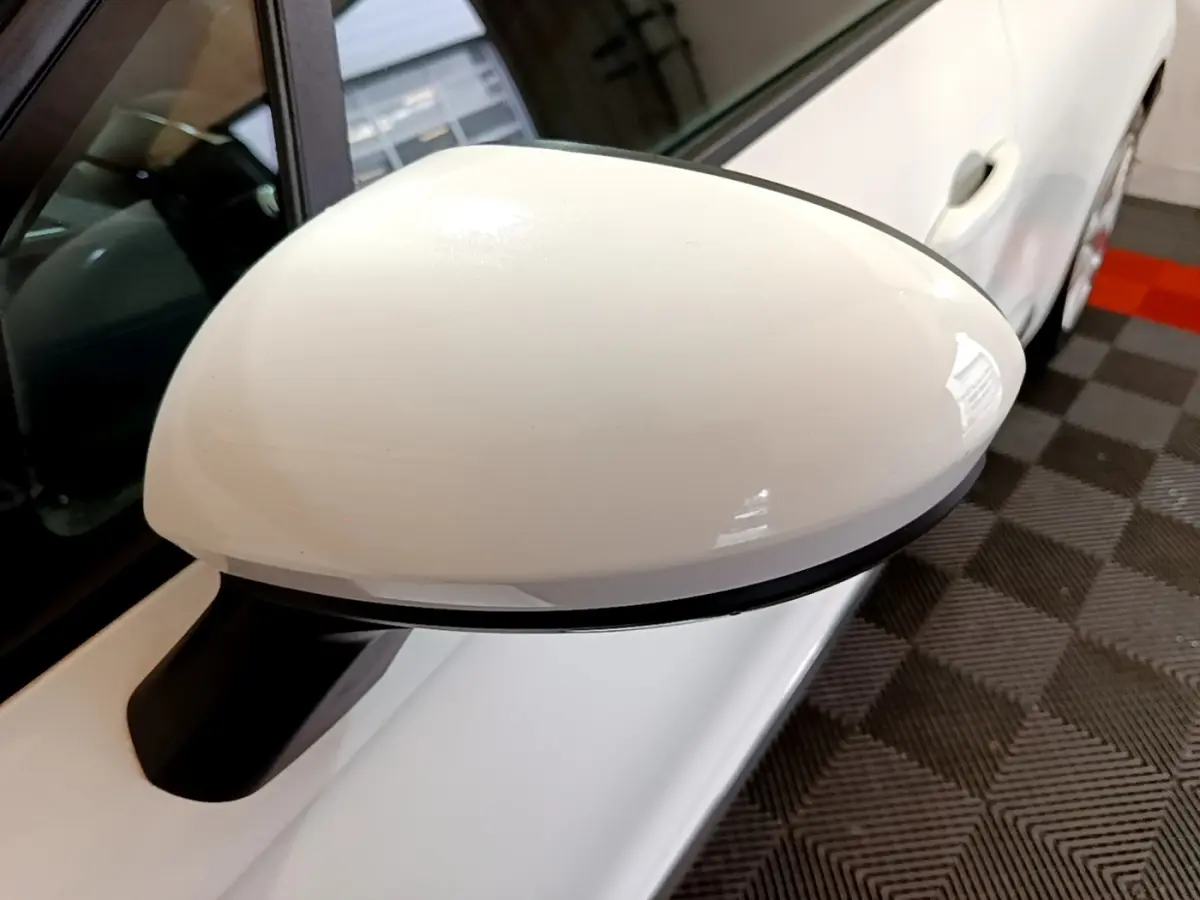 Rétroviseur blanc côté gauche d'une Renault Clio Business TCe 100 2020, vue rapprochée en intérieur garage.