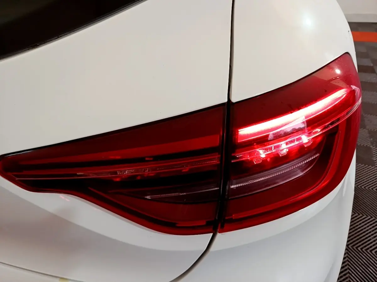 Gros plan sur le feu arrière droit rouge d'une Renault Clio Business TCe 100 blanche de 2020.