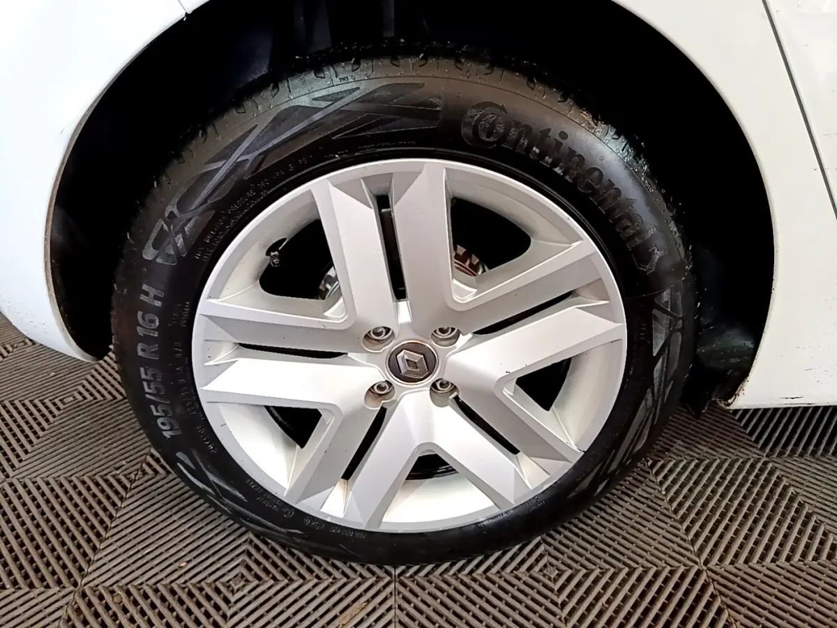 Gros plan sur la roue avant droite blanche d'une Renault Clio Business TCe 100 avec jante alliage et pneu Continental.