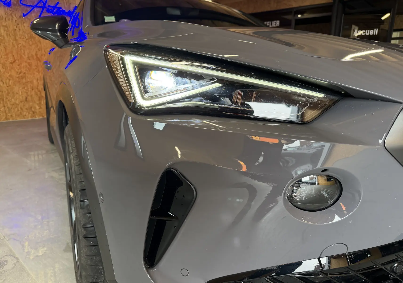 Gros plan sur l'avant droit gris du CUPRA Formentor 1.4 Hybrid 245 VZ, mettant en valeur le phare LED et la calandre.