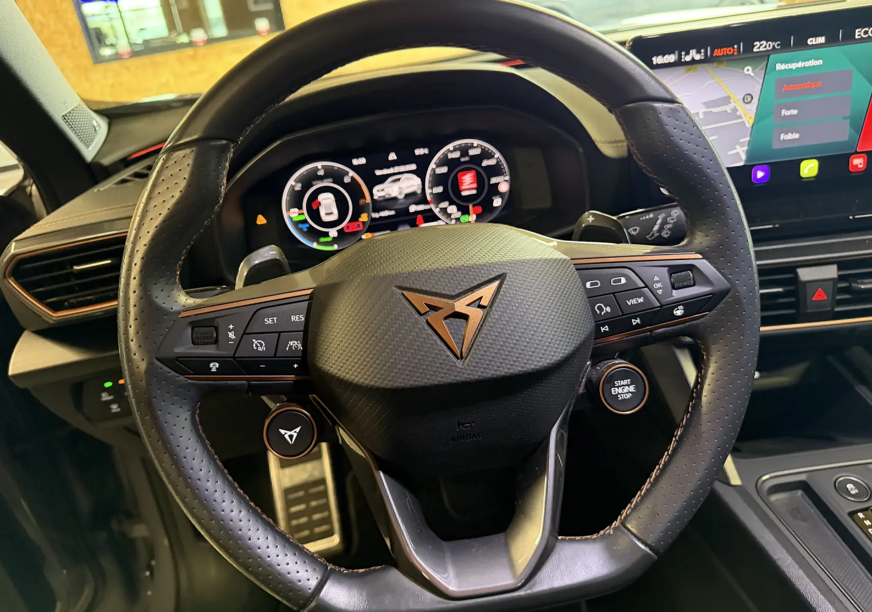 Vue rapprochée du volant noir perforé de la CUPRA Formentor 1.4 Hybrid 245 VZ avec tableau de bord numérique et écran tactile.