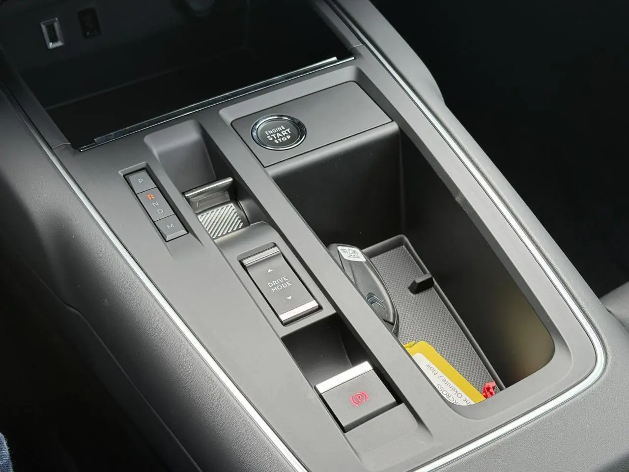 Gros plan sur la console centrale noire du Citroën C5 Aircross 2026 avec bouton start/stop et commandes de boîte automatique.