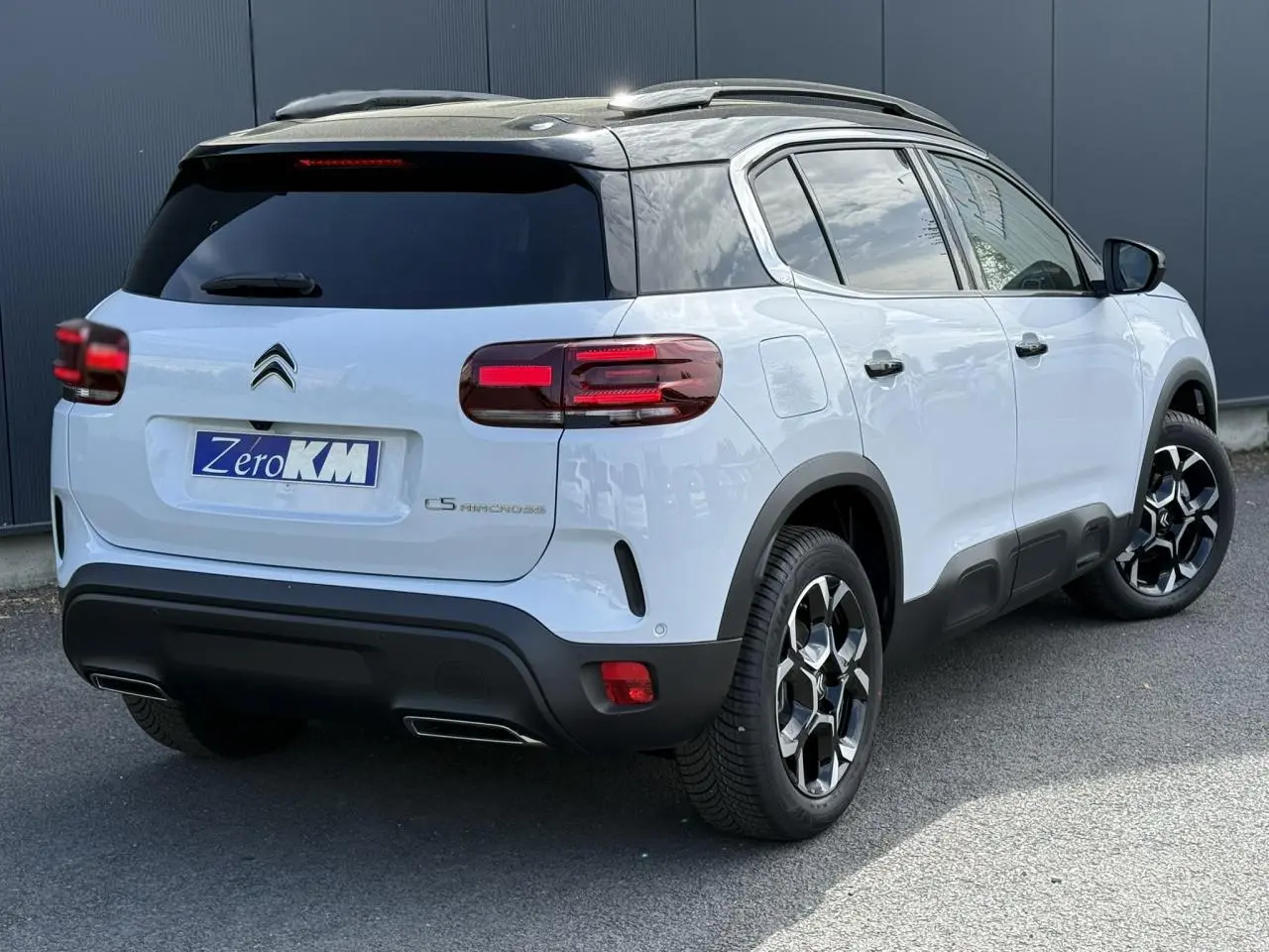 Vue 3/4 arrière droite du Citroën C5 Aircross blanc Okenite avec toit noir et jantes alliage bi-ton.