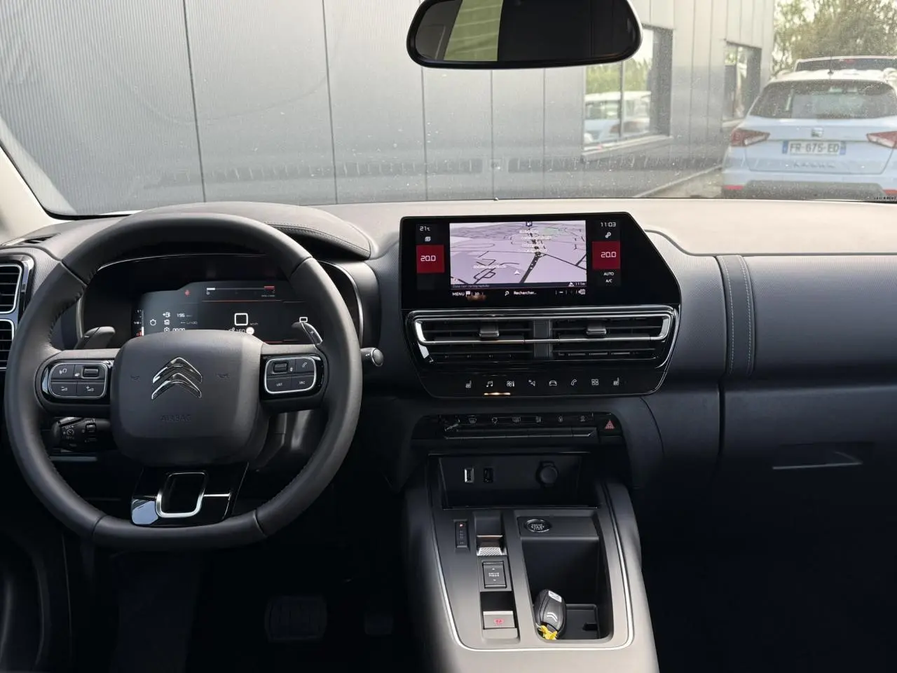 Vue frontale de l'intérieur noir du Citroën C5 Aircross 2026 avec écran tactile GPS et volant multifonctions.