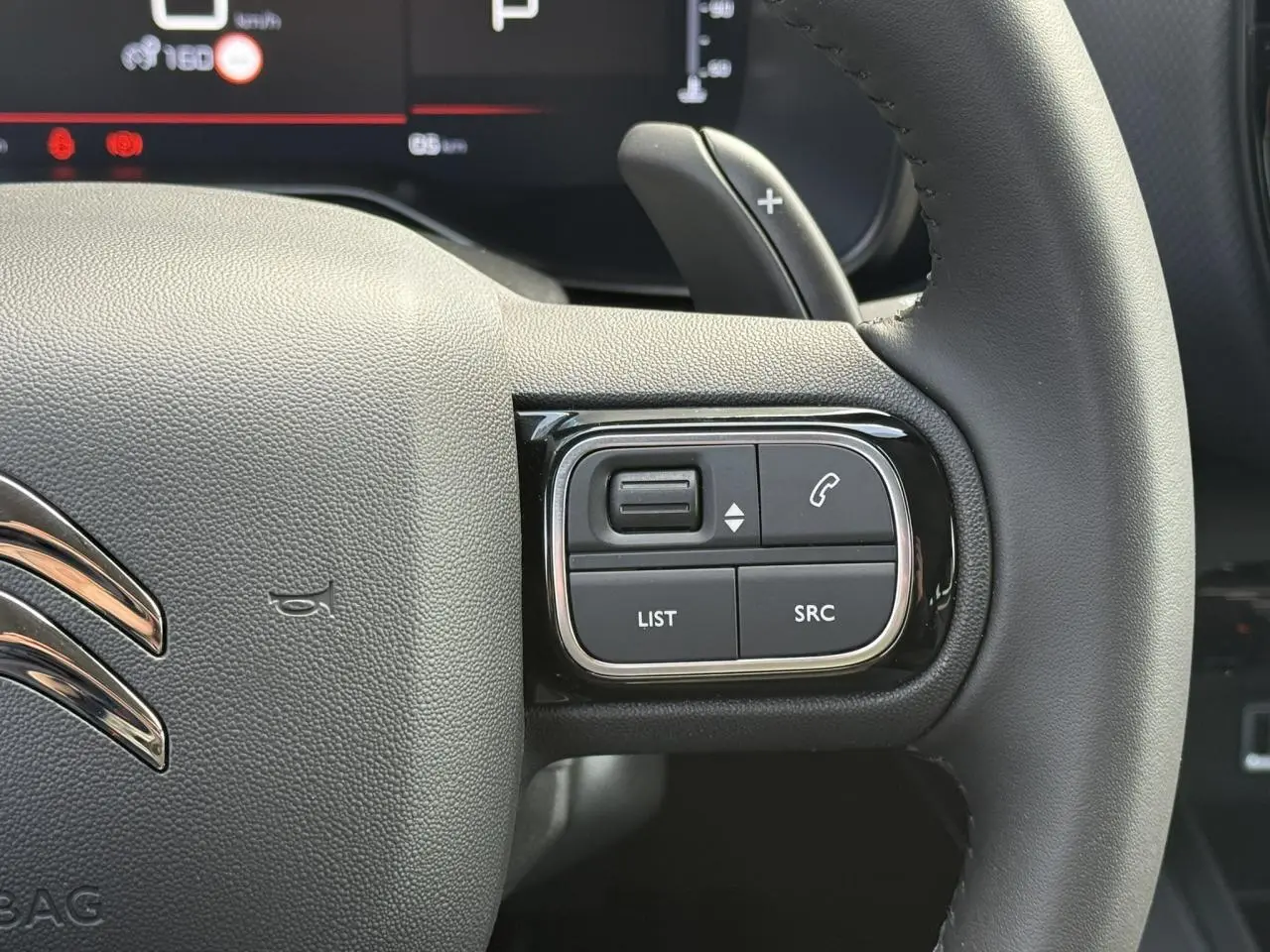 Gros plan sur les commandes à droite du volant noir du Citroën C5 Aircross 2026, avec palettes de changement de vitesse.