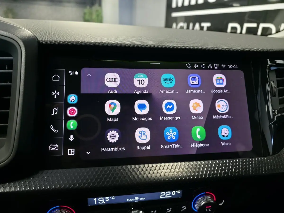 Écran tactile central de l'Audi A1 Sportback 2024 montrant l'interface smartphone avec décorations noires texturées.