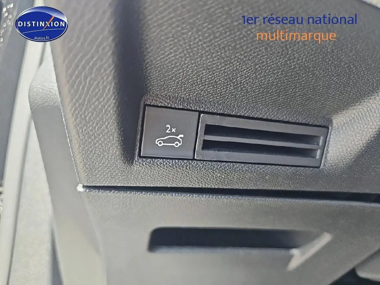 Gros plan sur le bouton d'ouverture du coffre dans l'habitacle noir du Peugeot 3008 1.2 hybrid 145 GT.
