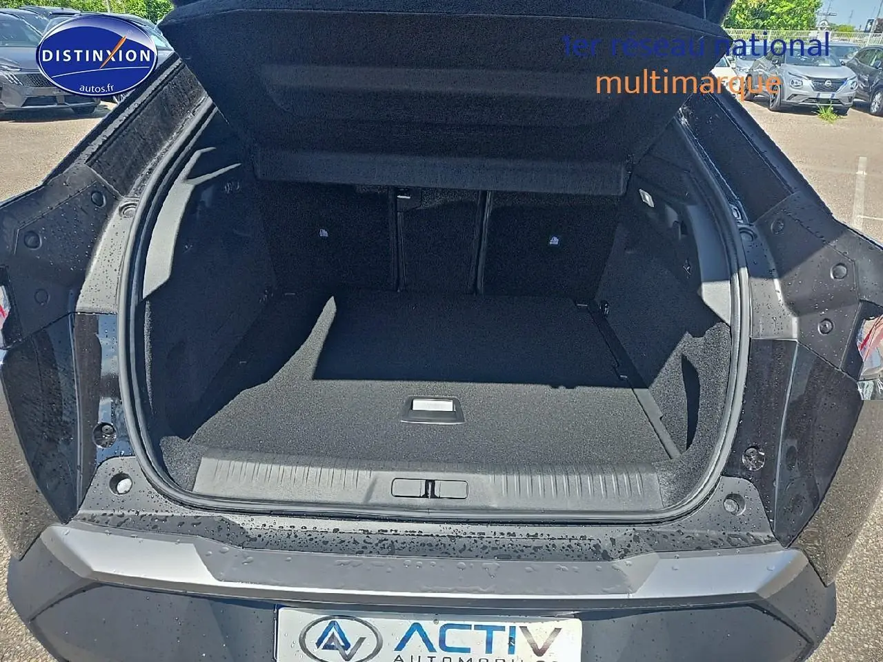 Coffre ouvert vu de l'arrière d'un Peugeot 3008 noir 2025 avec hayon et intérieur de coffre spacieux.