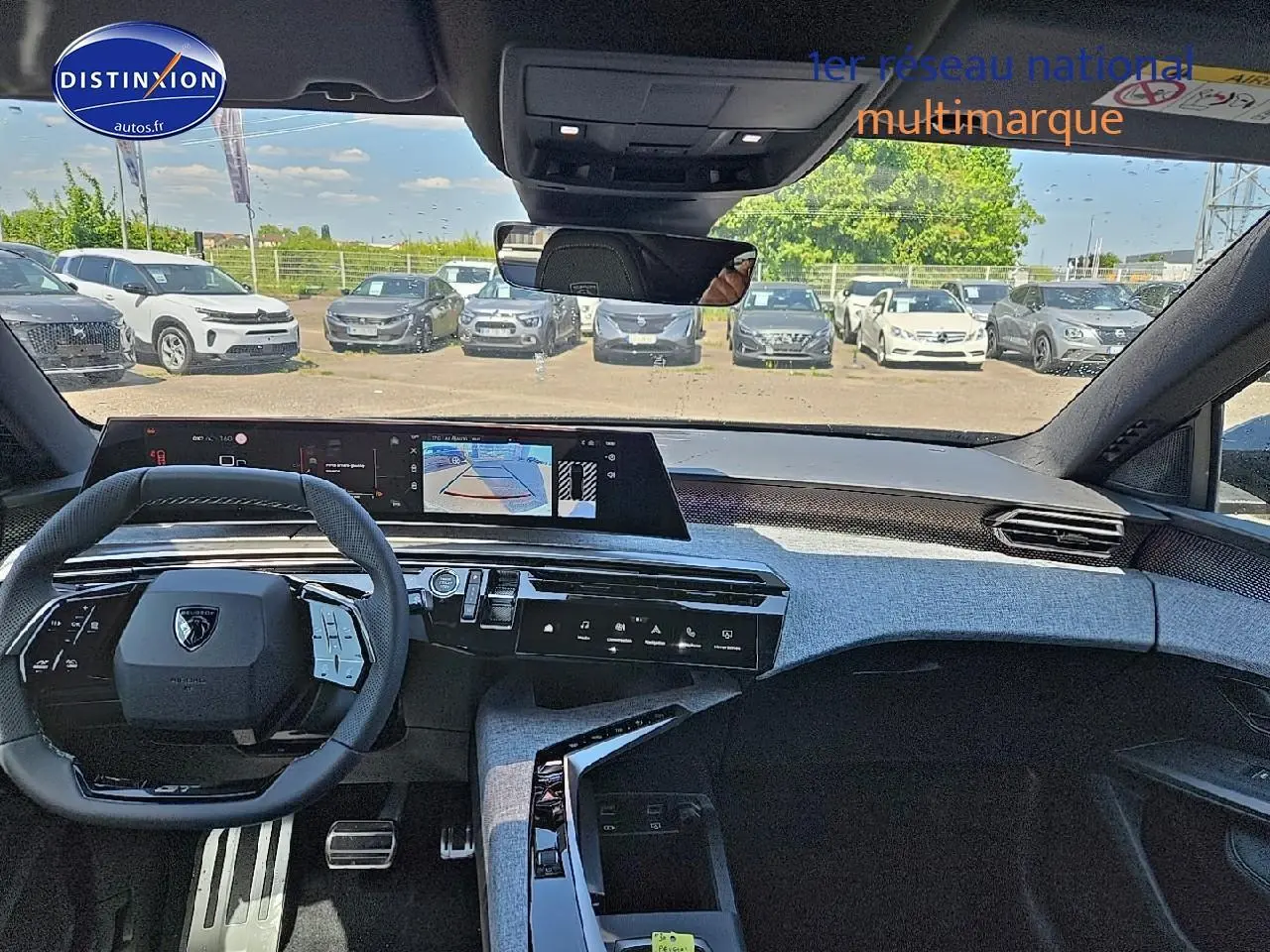 Vue intérieure avant du Peugeot 3008 noir 2025, volant multifonction et écran tactile large avec caméra de recul affichée.