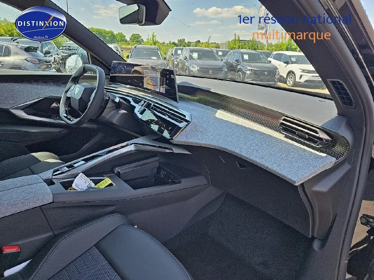 Vue intérieure côté passager du Peugeot 3008 hybride 2025, tableau de bord avec habillage gris et volant cuir noir.